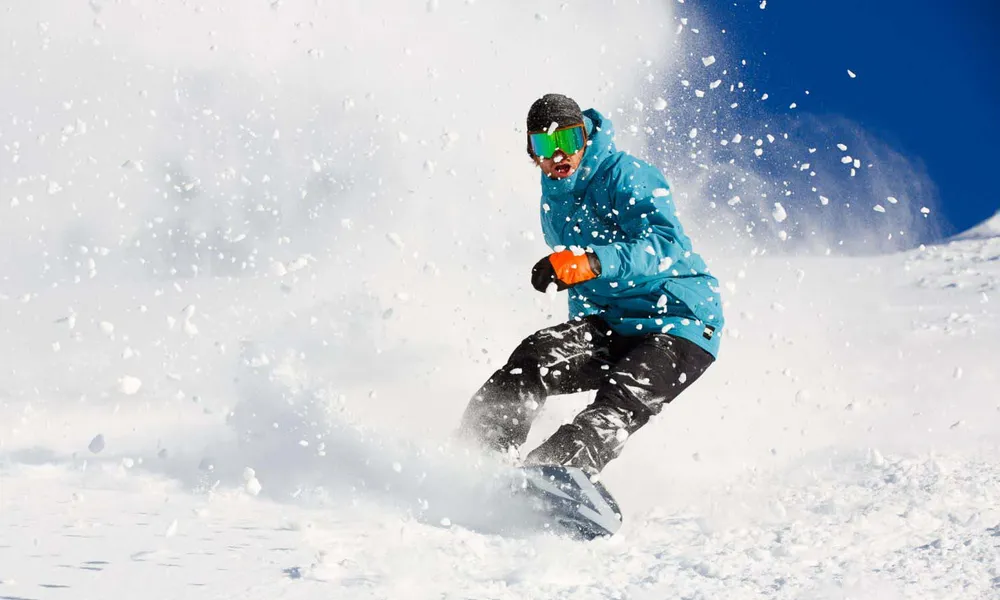 Snowboarder carving a turn on Gulmarg alpine terrain